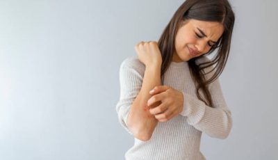 Women scratch the itch with hand , Concept with Healthcare And Medicine. Woman scratching arm on grey background. Allergy symptoms. Woman scratching her arm.